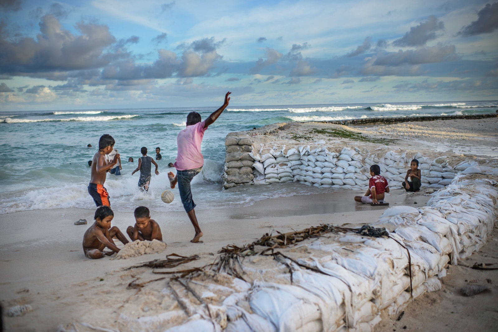 kids playing near sand bags