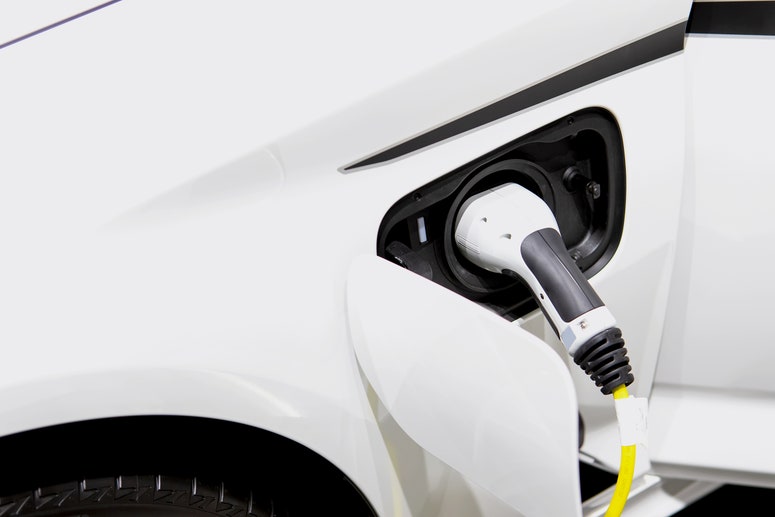 Electric vehicle with charger plugged in