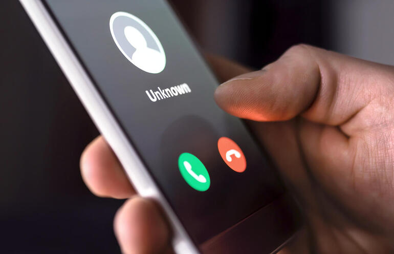 Phone call from unknown number late at night. Scam, fraud or phishing with smartphone concept. Prank caller, scammer or stranger. Man answering to incoming call.