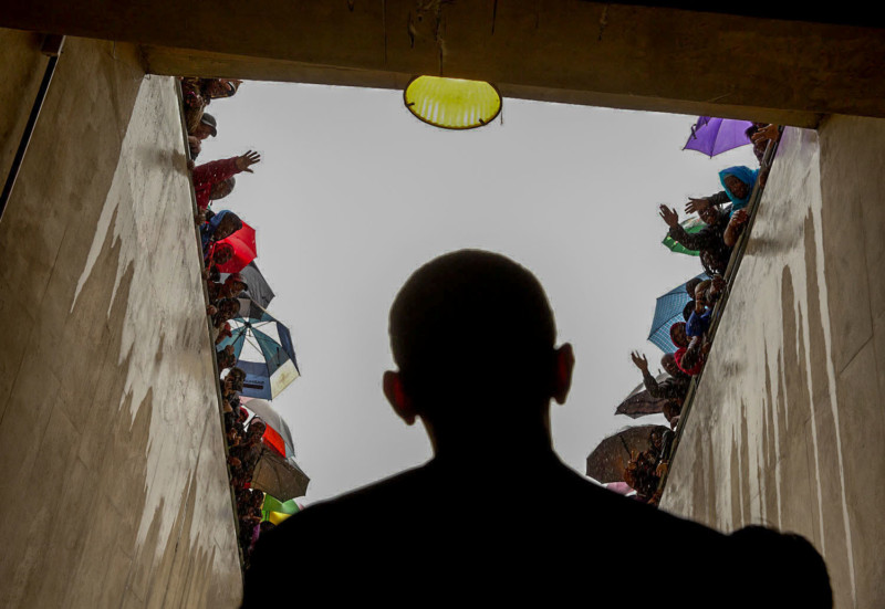 Dec. 10, 2012 "South Africans cheer as President Obama waits in a tunnel at the soccer stadium before taking the stage to speak at Nelson Mandela's memorial service. It was a long overnight flight to Johannesburg, a few hours on the ground in the pouring rain, and then a long flight back to Washington." (Official White House Photo by Pete Souza) This official White House photograph is being made available only for publication by news organizations and/or for personal use printing by the subject(s) of the photograph. The photograph may not be manipulated in any way and may not be used in commercial or political materials, advertisements, emails, products, promotions that in any way suggests approval or endorsement of the President, the First Family, or the White House.