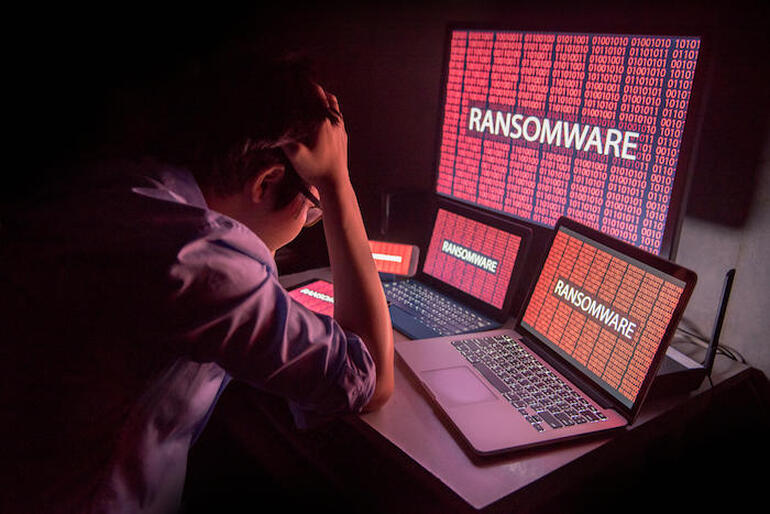 Young Asian male frustrated by ransomware cyber attack