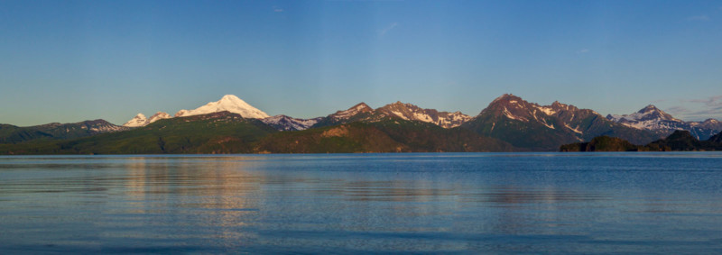 An Alaskan landscape with mountains, grassland, and water